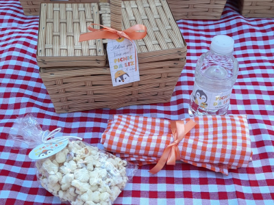 Cesta de palha, estilo chapeuzinho vermelho com saquinho de pipoca e uma garrafa de água